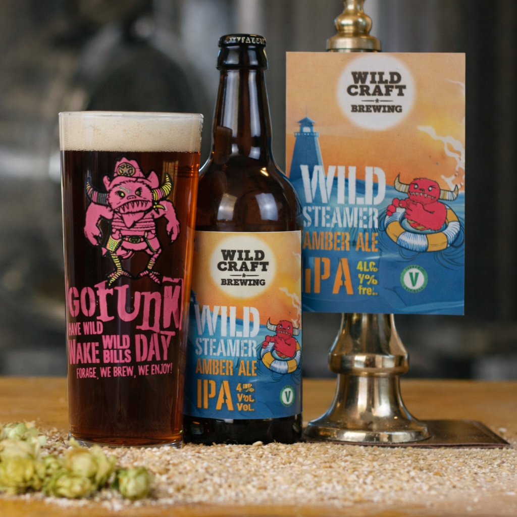 Beer bottle and glass with 'Wild Craft Brewing' branding on a wooden surface.