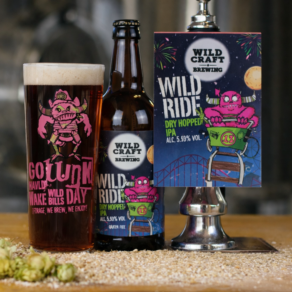 Bottle of Wildcraft Brewing beer with a glass and packaging on a wooden surface.