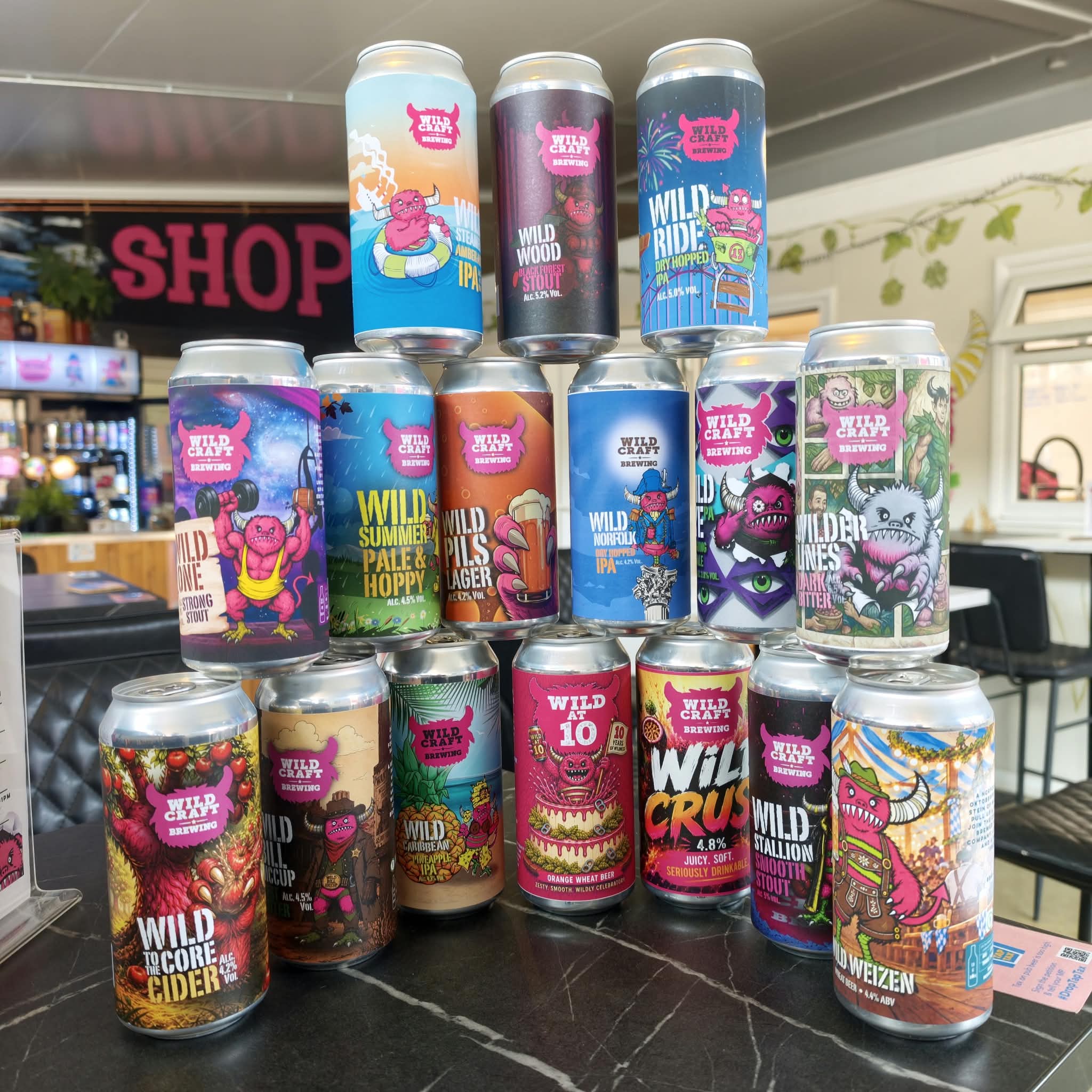 A selection of Wildcraft beer cans against a colourful splash background